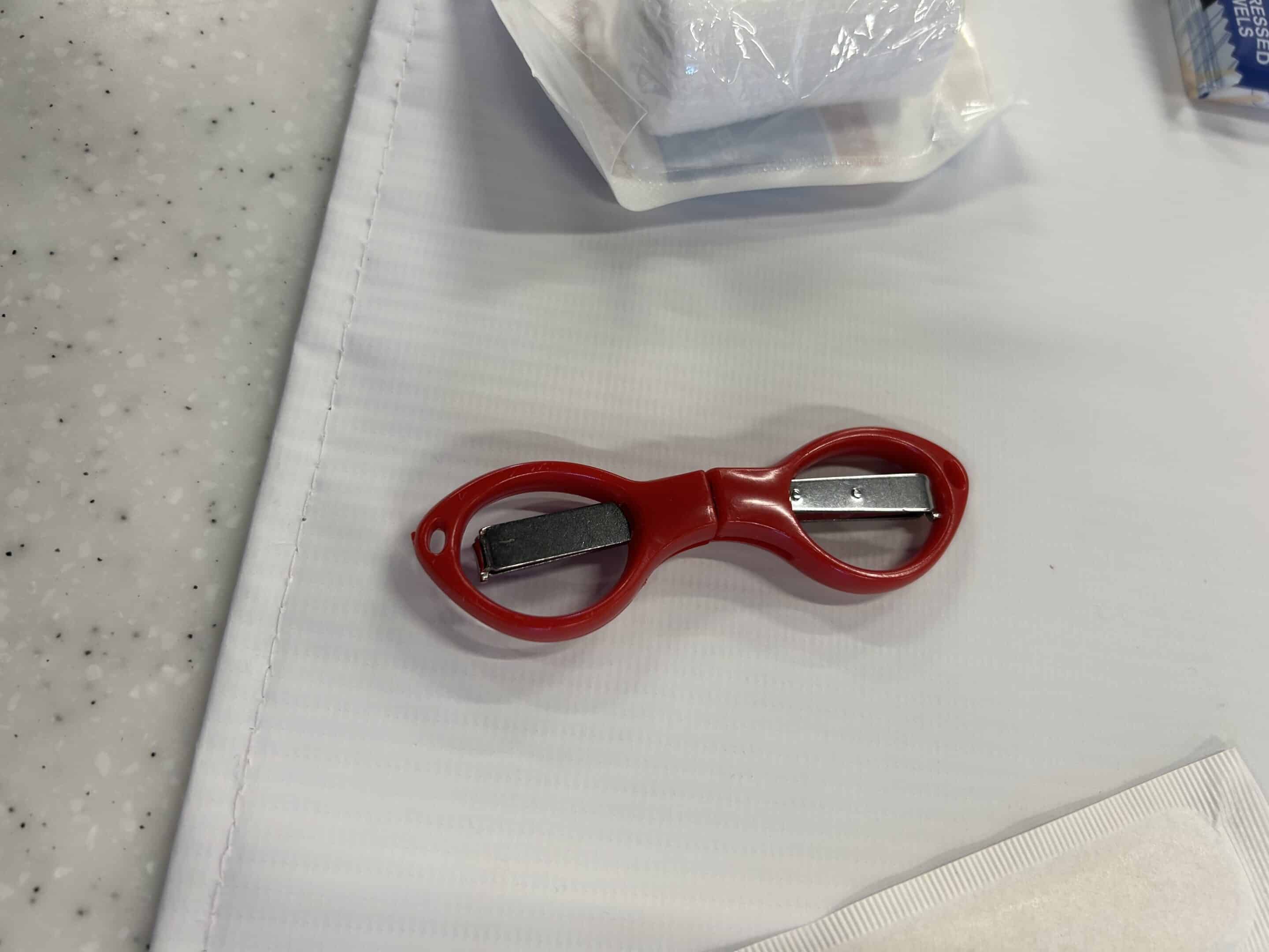 Collapsible scissors for pet first aid kit used to safely cut bandages and trim fur during dog and cat wound care